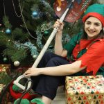 elf by the tree with snow shovel